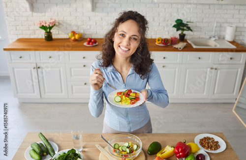 Portrait of a woman eating vegetable salad on kitchen at home, highlighting healthy food and wellness, serene moment in a personal space dedicated to nutritious meals and culinary enjoyment.