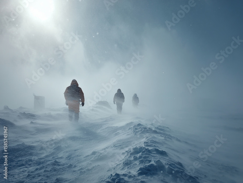 Explorers hiking through arctic blizzard in snowy landscape