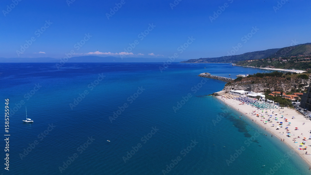 Fototapeta premium Aerial view of Tropea beach, a popular tourist destination in Calabria, Southern Italy, with its crystal clear turquoise water and white sand