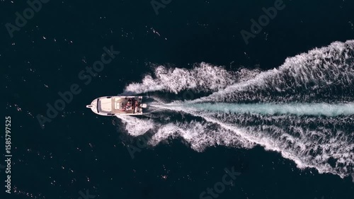 Bateau vu du ciel traversant la mer en créant des vagues, filmé en drone en vue verticale