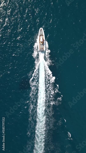 Bateau rapide vu du ciel qui crée des vagues, filmé en drone en vue verticale
