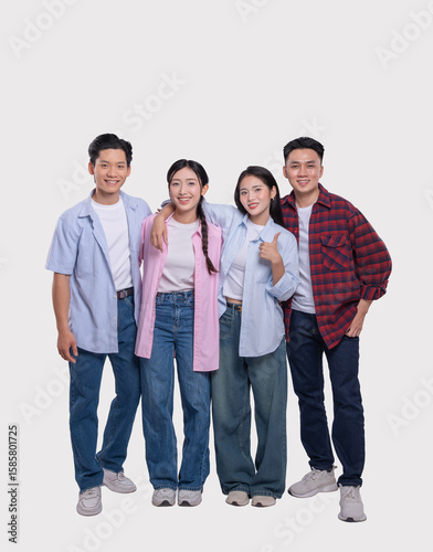 Four cheerful friends stand shoulder to shoulder radiating positivity in their casual attire