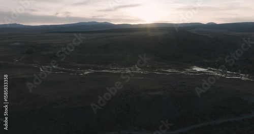 Aerial panoramic view of sunset at natural rural landscape valley with white van rolling in the distance