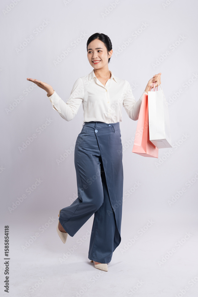 Ταπετσαρία Smiling woman in dressy casual attire holds shopping bags presenting something t