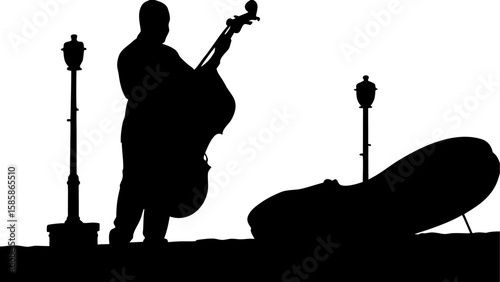 Silhouette of a musician playing a double bass next to a street lamp with another bass lying nearby