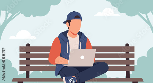 A young man wearing a baseball cap sits on a park bench with a laptop, enjoying the outdoors while working or studying in a serene environment.