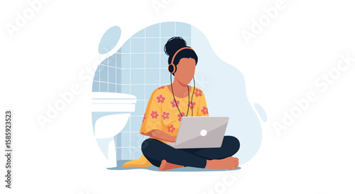 A young woman with dark hair sits on a floor with a laptop, wearing headphones, and working in a bathroom setting, engaged in online activity.