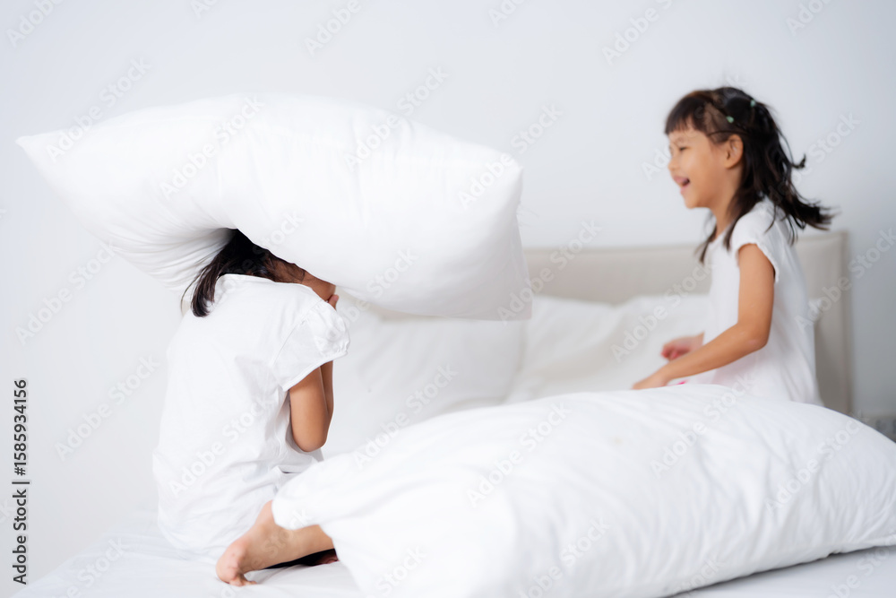 Two little asian girls playing on bed Two little asian girls playing on bed