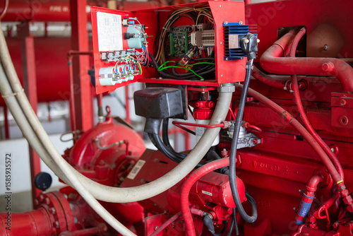 Fire pump generator system with engineer performing inspection on red industrial equipment ensuring safety and functionality in mechanical room environment