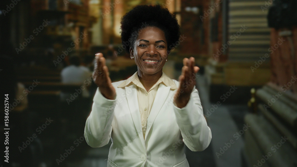 Obraz premium Woman kisses camera in church setting wearing white suit with blurred background highlighting the indoor environment.