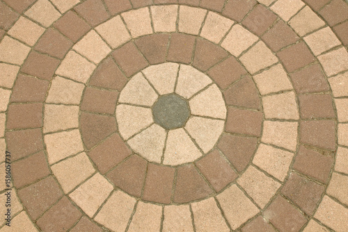 The pattern of the public walkway stone floor is made in a circular shape.