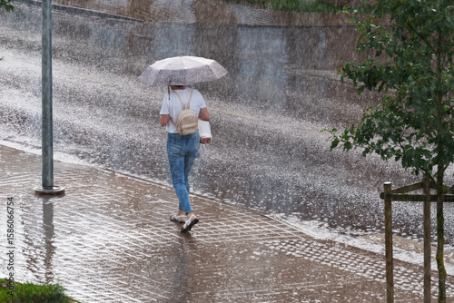 little girl walking in the rain