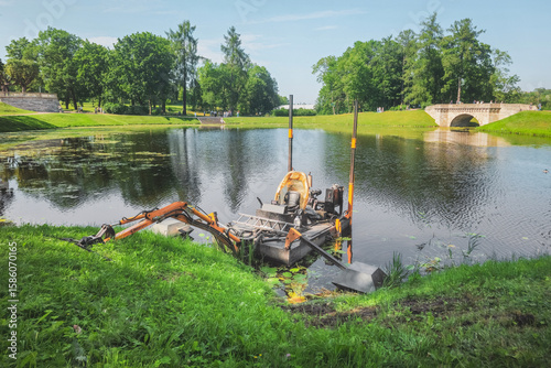 Fotografija Dredger for cleaning reservoirs in summer park.