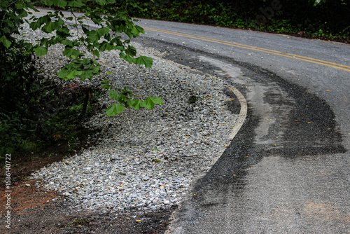Foto a road shoulder recently replenished with gravel along a sloped and winding region