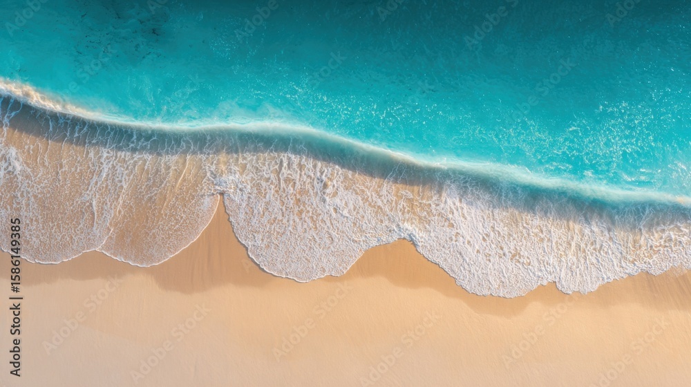Obraz premium Aerial view of pristine sandy beach shoreline with gentle waves and clear turquoise water.
