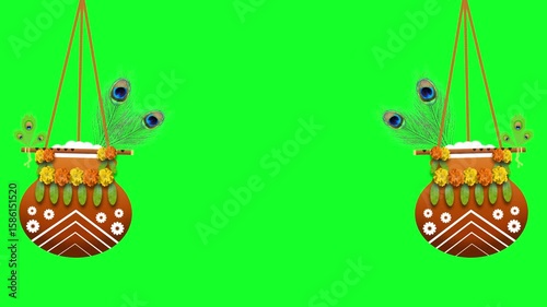 Decorated dahi handi with flute and peacock feathers on green screen with swinging effect. Concept for janmashtami festival decoration.