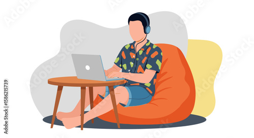 A relaxed man in casual attire works remotely on his laptop while comfortably seated on an orange bean bag with headphones on.