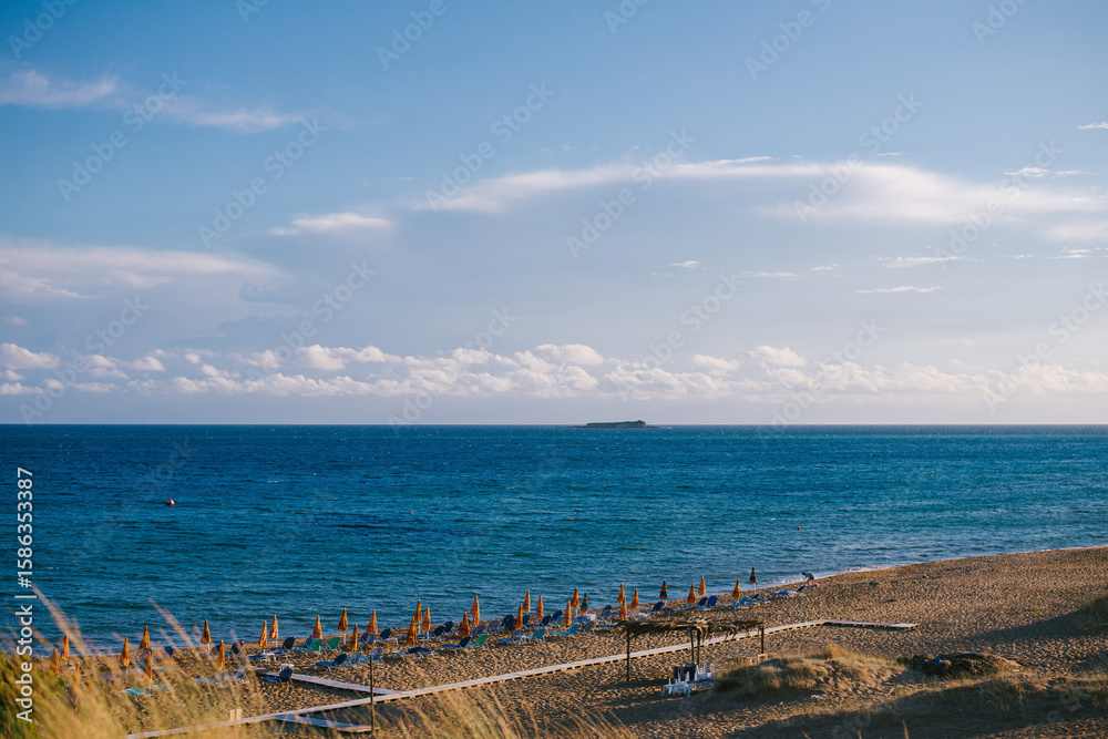 Fototapeta premium Serene Beach with Sun Loungers and Umbrellas