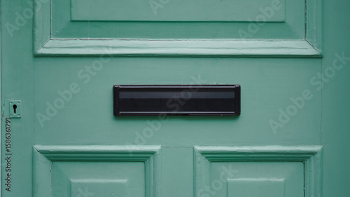 Elegant wooden english door with decorative mail slot and charming texture