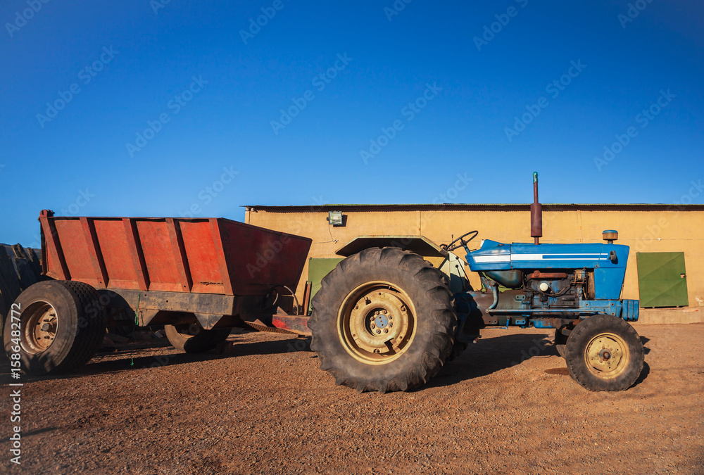 Fototapeta premium An agricultural tractor without cab in parking lot in hot country.