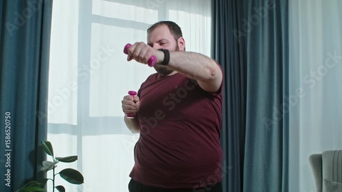 Man with overweight trying to lose weight doing exercises with dumbbell