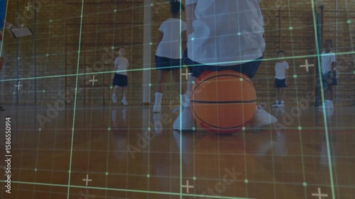 Coach conducting PE class balance drill, student kneeling on basketball balancing with grid overlay