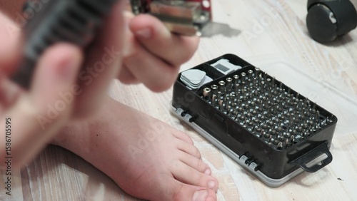 technician hold the screwdriver for repairing the laptop. computer hardware, repairing, upgrade and technology. professional technicial at workplace concentrated. focus on hands
