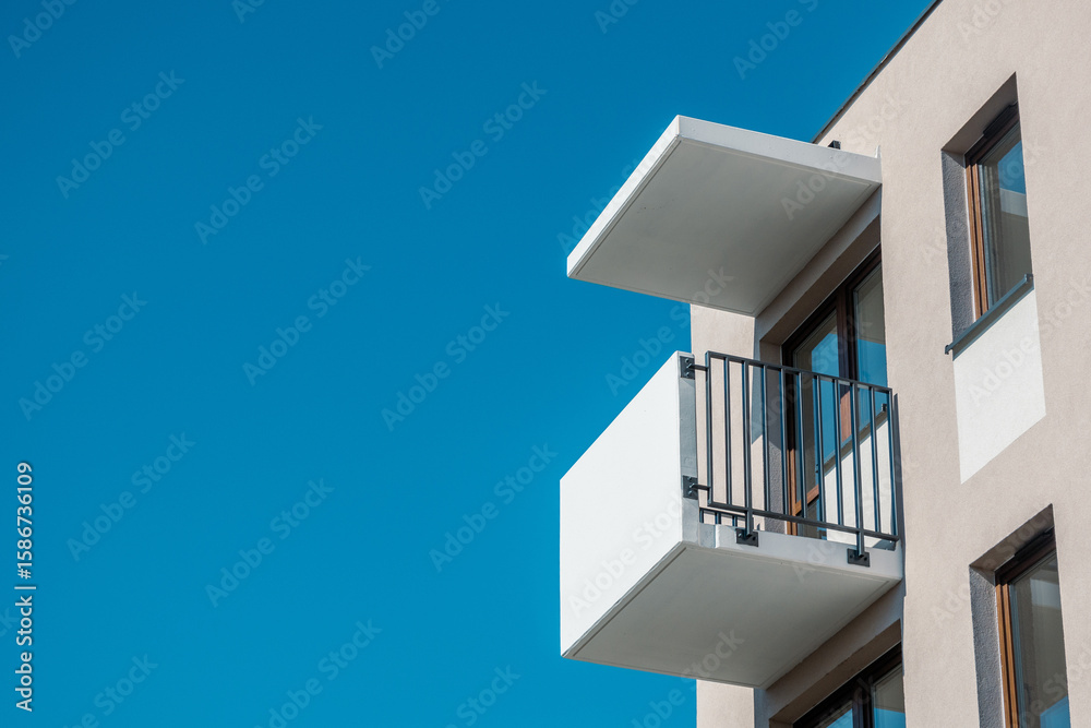 Contemporary apartment building with white balcony against clear blue sky Contemporary apartment building with white balcony against clear blue sky