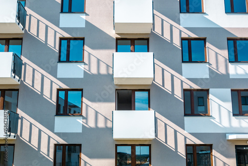 Symmetrical apartment building facade with balconies and long shadows