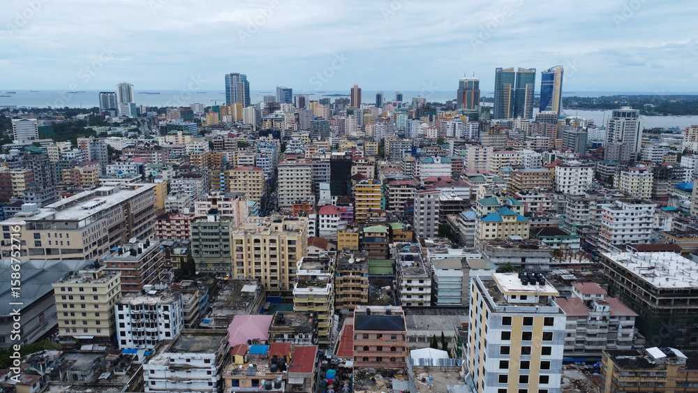 Obraz premium Aerial view of a densely populated urban area with various buildings and a distant body of water tanzania