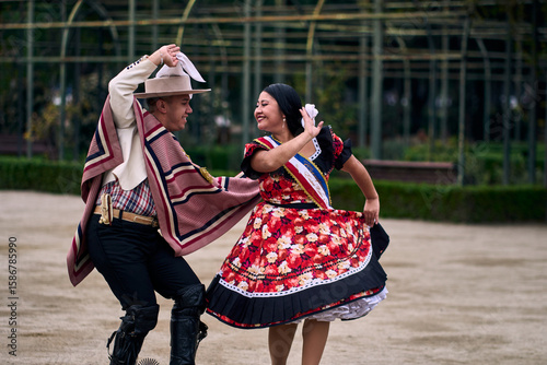 Portrait of a smiling young couple dressed as Chilean huasos, posing and joyfully dancing cueca outdoors. Traditional Chilean dance. Chilean traditions, celebrations, and culture.