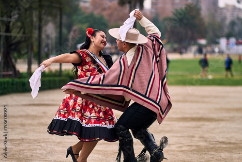 Portrait of a smiling young couple dressed as Chilean huasos, posing and joyfully dancing cueca outdoors. Traditional Chilean dance. Chilean traditions, celebrations, and culture.