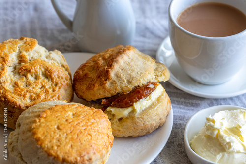 Traditional british scones with clotted cream and apricot jam for tea time