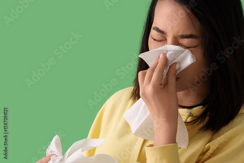 Ill Asian woman with tissue...