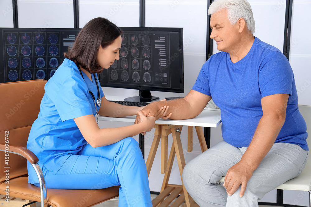 Fototapeta premium Female physiotherapist working with senior patient in rehabilitation center
