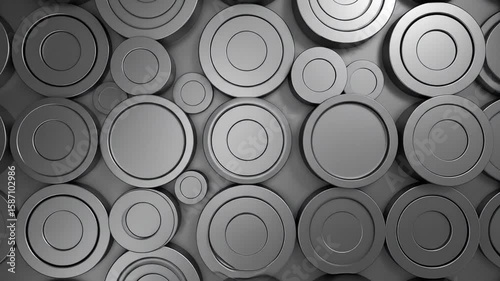 Metallic, layered circles of varying sizes, arranged randomly, with a smooth, matte texture. Light source creates shadows
