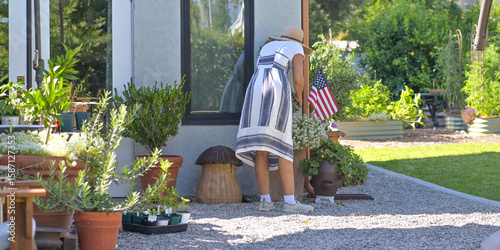 Εκτύπωση καμβά Woman tending to plants in the quaint backyard patio
