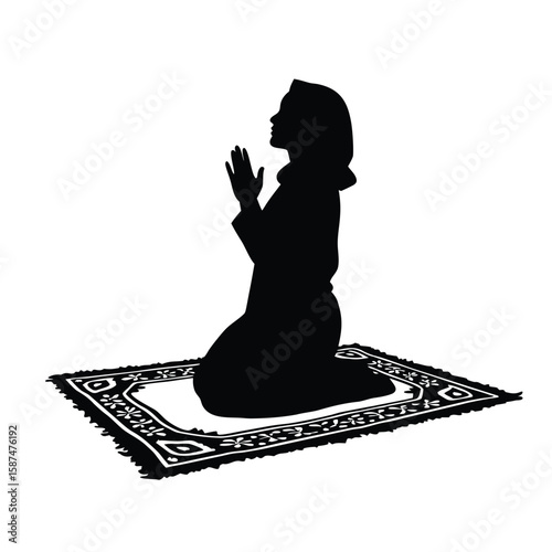 Silhouette of woman praying on rug kneeling