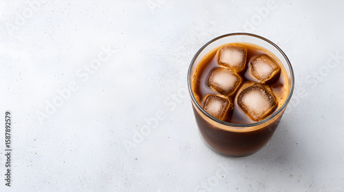 A top view of a glass filled with iced black coffee, glistening with ice cubes under natural light. white 79802364 1