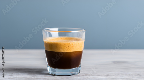 A beautifully layered coffee in a clear glass cup, showcasing rich colors and intricate textures. white 21744427 1