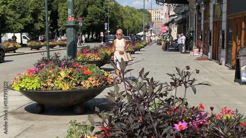 Woman walking the city center streets in Oslo, Norway.  Footage from Karl Johan street with the royal castle in the background.