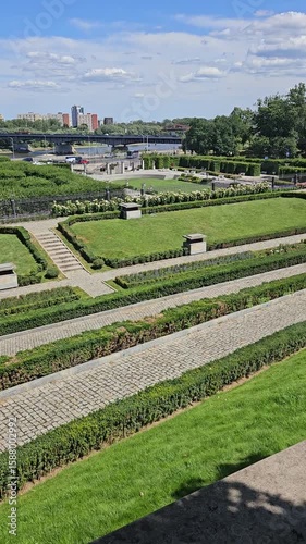Scenic City Park Garden with River and Urban Skyline on Sunny Day