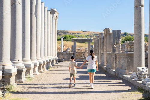 A boy and a girl walk along the street of an ancient city. Travel.