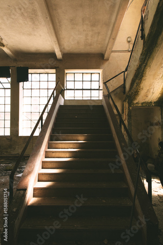 scalinata in cemento che conduce ad un piano superiore, all'interno di un edificio vecchio ed abbandonato