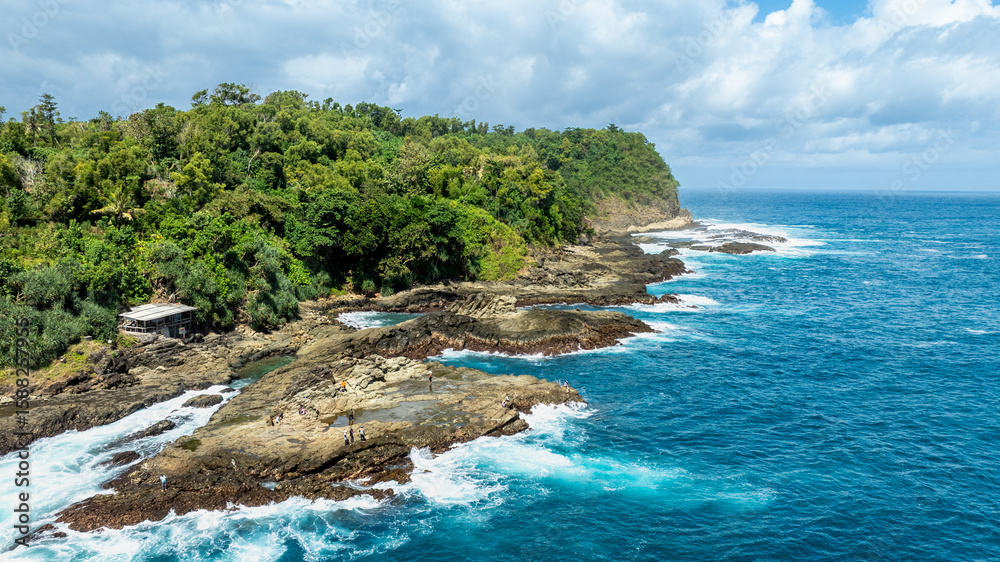Fototapeta premium Lush Green Cliff Above Tropical Reef