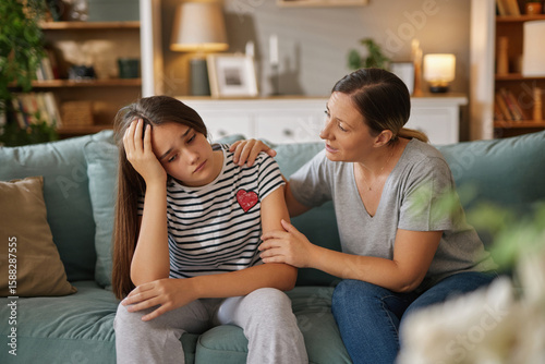 Quadro em tela In a comfortable living room, a teenager expresses feelings of distress while a supportive parent listens attentively, fostering emotional connection and guidance in a challenging moment