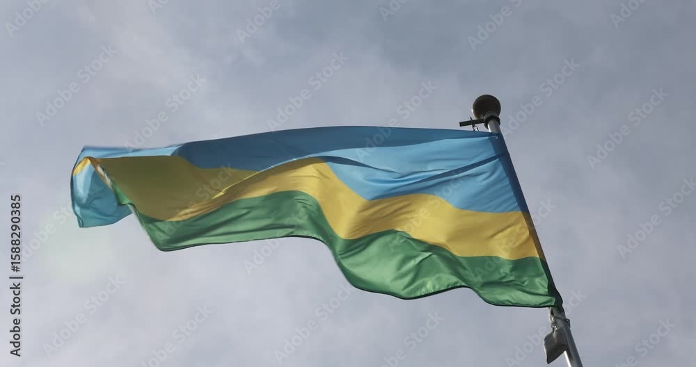 The flag of Rwanda is captured in close-up. The flag of Rwanda, fluttering against the blue sky, is the national symbol of Rwanda. The video is presented in 4K format. Great for news.