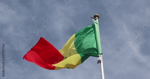 The Senegalese flag is captured in close-up. The flag of Senegal, flying against the blue sky, is the national symbol of Senegal. Great for news. The video is presented in 4K format.