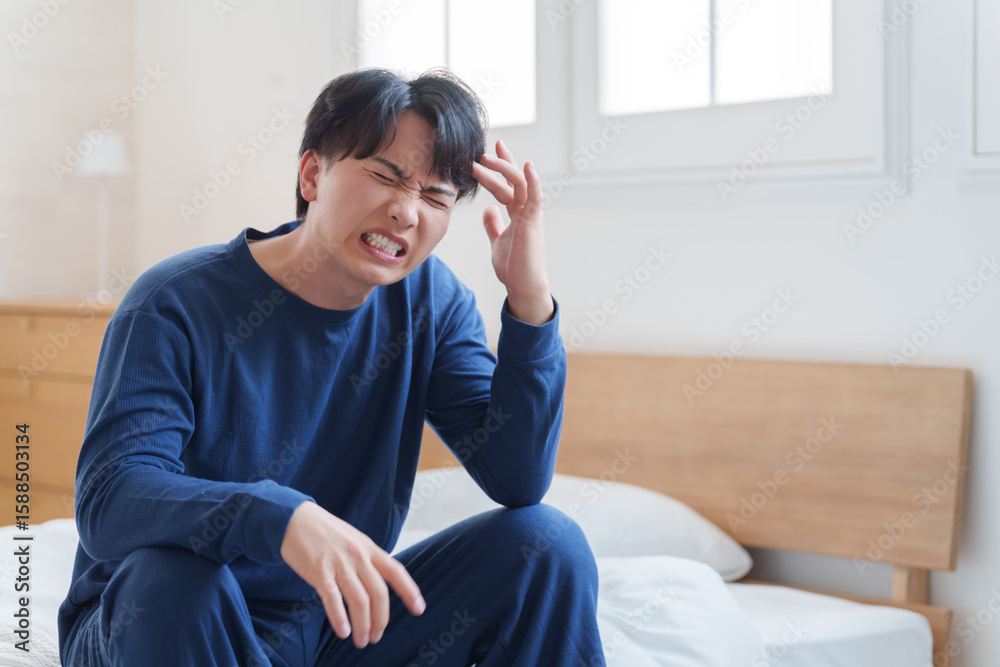 Fototapeta premium ベッドで落ち込む男性