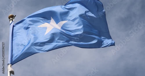 The Somali flag is captured in close-up. The Somali flag fluttering against the blue sky is the national symbol of Somalia. Great for news. The video is presented in 4K format.